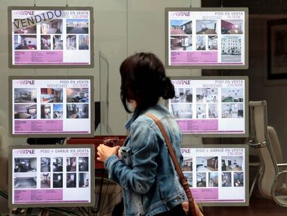 Una persona pasa ante el escaparate de una agencia inmobiliaria en Valencia, en una imagen de archivo.