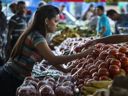 Una mujer compra fruta en un mercado local en Alajuela (Costa Rica).