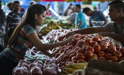 Una mujer compra fruta en un mercado local en Alajuela (Costa Rica).