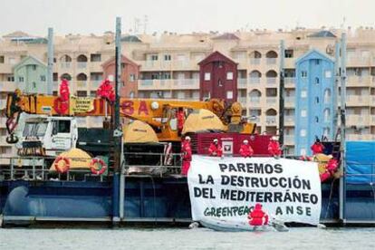 Activistas de Greenpeace y ANSE han desplegado grandes carteles como el de la imagen.