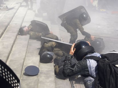 Policiais ajudam seus colegas feridos durante os confrontos com os opositores à reforma constitucional em frente ao Parlamento de Kiev, Ucrânia.