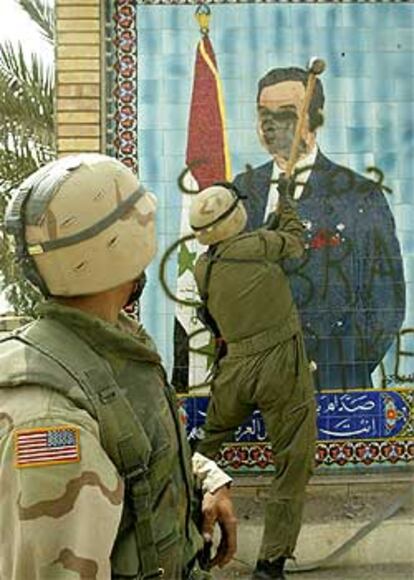 Un militar destruye con un mazo un mural de Sadam Husein en Kerbala.