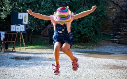 Una niña salta en el parque. 