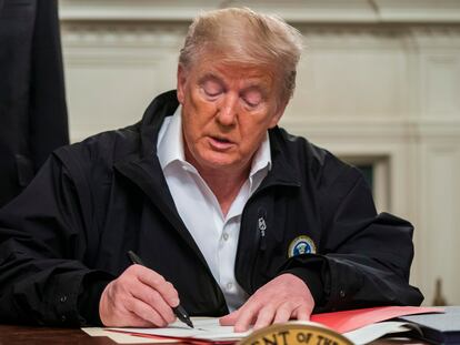 Donald Trump firma la ley de emergencia, este viernes en la Casa Blanca.