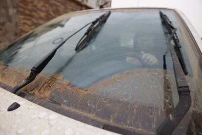 Un conductor trata de limpiar los cristales de su automóvil del polvo en suspensión que proviene del Sáhara que las últimas lluvias caídas en Madrid han esparcido por las calles y vehículos de la capital.