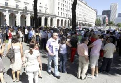 Funcionarios públicos que trabajan en Nuevos Ministerios, en Madrid, cortan el tráfico este mediodía en el paseo de la Castellana en protesta por los nuevos ajustes aprobados por el Gobierno.