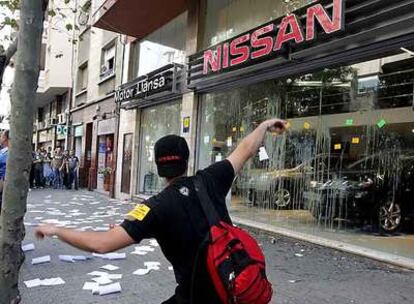 Un manifestante lanza un huevo contra un concesionario de Nissan en Barcelona.