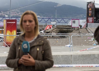 Una reportera retransmite frente a la pasarela desplomada en Vigo.