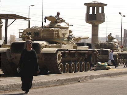 Una mujer camina delante de tanques que guardan la prisión de Tora, en las afueras de El Cairo, en 2015.