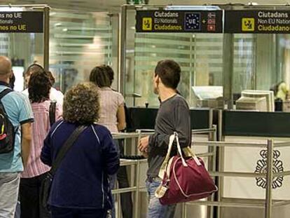 Pasajeros llegan al puesto de control del Cuerpo Nacional de Policía en la terminal A del aeropuerto de El Prat.