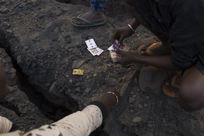Niños jugando a las cartas en una mina de carbón. Muchos críos comienzan a recolectar carbón desde los siete años antes de la escuela para ayudar a mantener a sus familias.