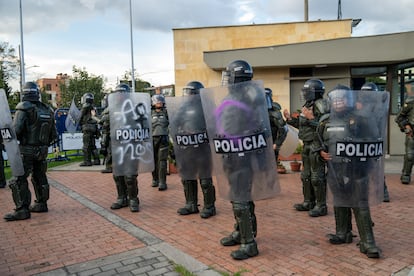 Policías con escudos pintados por las manifestantes durante el recorrido en Bogotá.