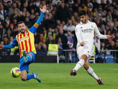 Marco Asensio remata ante José Gaya durante el partido entre el Real Madrid y el Valencia, en el Santiago Bernabéu este jueves.
