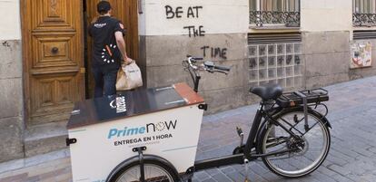 Un empleado de Amazon reparte productos con una bicicleta eléctrica en Madrid.