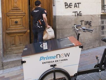 Un empleado de Amazon reparte productos con una bicicleta el&eacute;ctrica en Madrid.