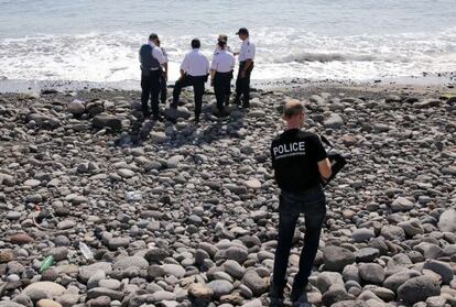 Varios polic&iacute;as inspeccionan un objeto met&aacute;lico hallado en la playa de Saint-Denis, en la isla de Reunion, el 2 de agosto.  