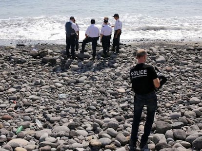 Policiais inspecionam um objeto metálico encontrado na praia de Saint-Denis, na ilha Reunião, em 2 de agosto.