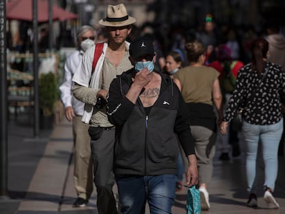 Varios transeúntes caminan en las calles del Centro Histórico de Ciudad de México.