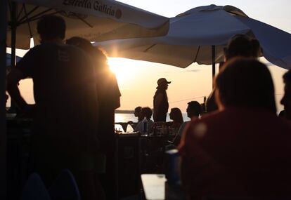 Varios personas acuden a uno de los conciertos que se desarrollan durante la tarde junto al mar.