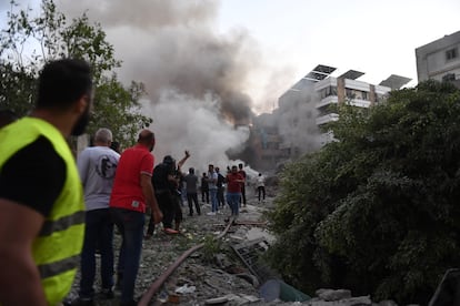 Los equipos de bomberos y ciudadanos libaneses inspeccionan la zona alcanzada por los ataques israelíes esta tarde en Beirut.