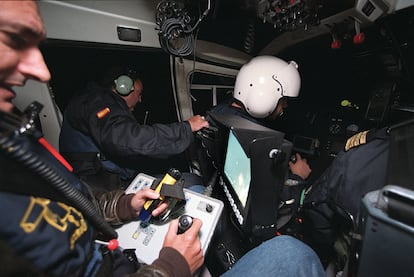 Interior de uno de los helicópteros del SVA  durante una "noche de caza" en el Estrecho del Servicio de Vigilancia Aduanera de Algeciras (Cádiz) con participación del escritor Arturo Pérez Reverte con motivo de la publicación de su novela "La reina del sur". En el centro de la imagen, asomado al exterior del helicóptero, José Luis Domínguez Iborra. FOTO: RICARDO GUTIÉRREZ