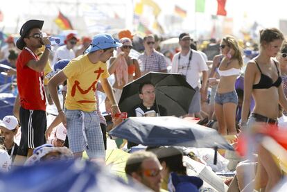 Varios jóvenes combaten el calor en Cuatro Vientos, mientras esperan la llegada del Papa.