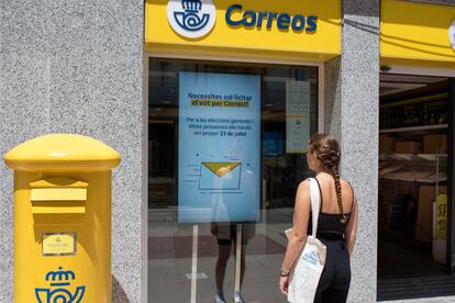 Una mujer observa la información sobre el voto por correo frente a la oficina de Correos de Maó (Menorca).