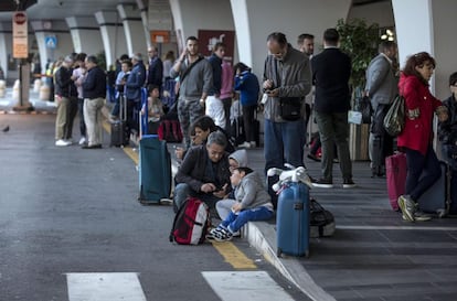 Un denso humo se aprecia aún en toda la zona y han sido suspendidos todos los trenes que llegan a Fiumicino, así como las carreteras de acceso. En la imagen, varios pasajeros esperan junto a la terminal.