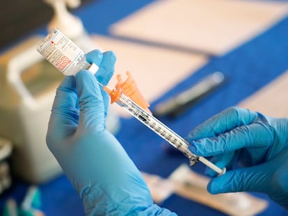 A nurse prepares a syringe of a COVID-19 vaccine at an inoculation station in Jackson, Miss., July 19, 2022.