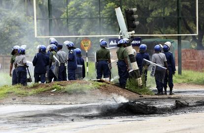 Miembros de la policía antidisturbios avanzan por las calles de Harare durante los enfrentamientos.