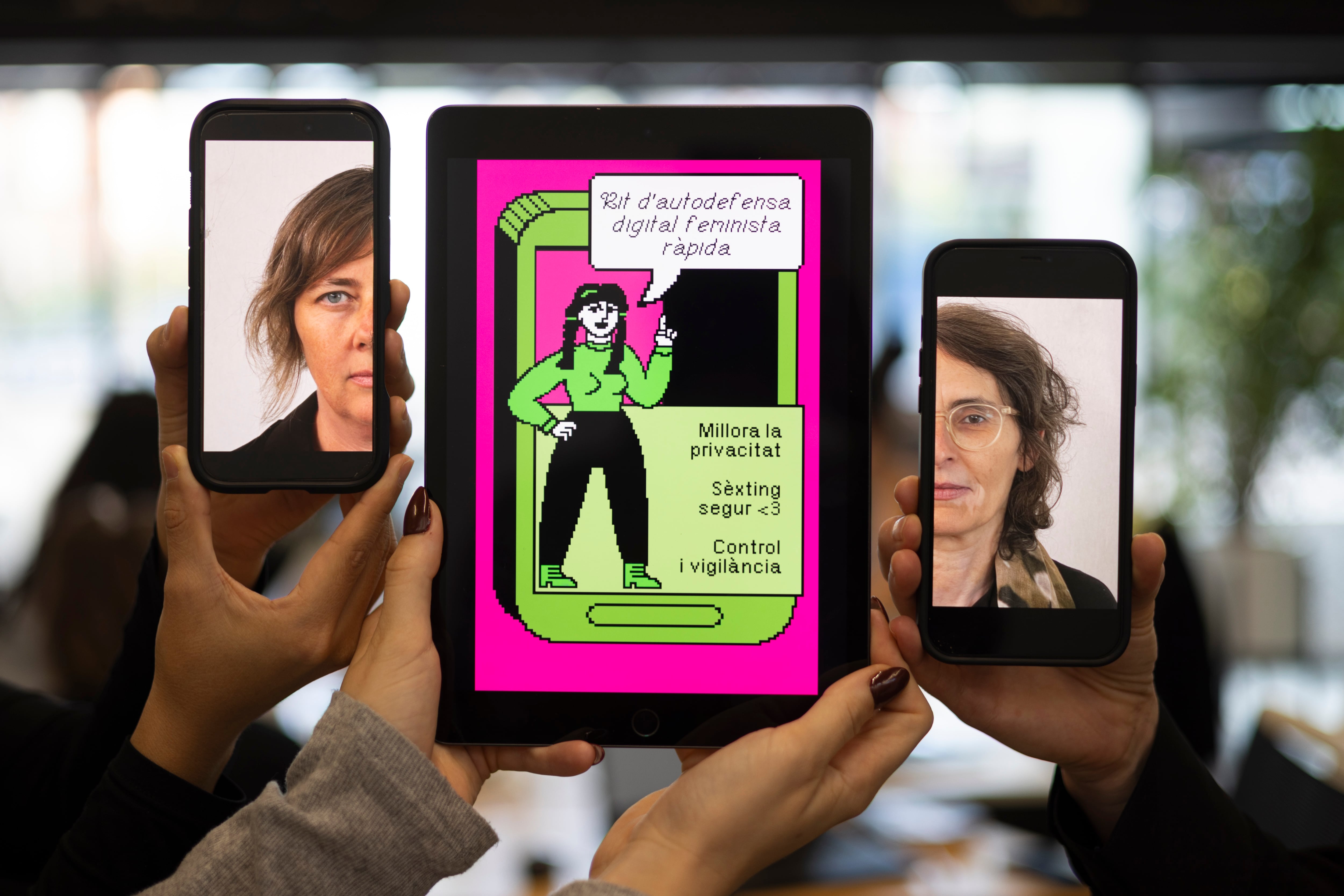 Eva Cruells y Alex Cadon con una tablet en la que aparece una de las ilustraciones del kit de autodefensa digital feminista creado por Fembloc.
