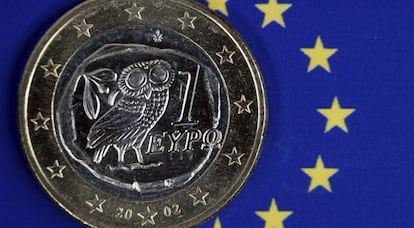 Una moneda de euro griego permanece sobre el emblema de la Uni&oacute;n Europea. 