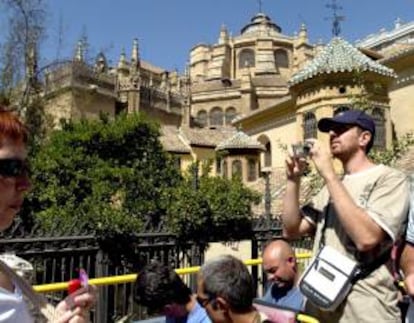 Un turista fotografía el cimborrio de la catedral de la ciudad de Granada.