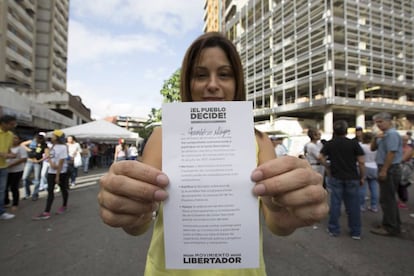 FE DE ERRORES: En una primera versión de esta fotogalería, algunas imágenes del simulacro de las elecciones constituyentes organizado por el Gobierno venezolano se atribuyeron por error a la consulta convocada por la oposición. La equivocación se debe a la difusión errónea de una serie de la la agencia EFE, que posteriormente ha corregido los pies de foto.  En esta imagen, una mujer muestra una papeleta de votación hoy 16 de julio del 2017 en Caracas (Venezuela).