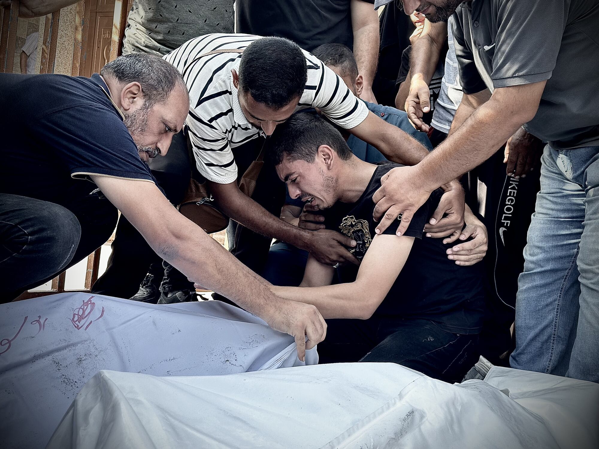 GAZA CITY, GAZA - JULY 25: Relatives of those who lost their lives in Israeli attacks in Khan Yunis mourn near the bodies wrapped in shrouds, which were brought to Nasser Hospital in Gaza City, Gaza on July 25, 2024. At least 7 Palestinian were killed in the attack. (Photo by Doaa Albaz/Anadolu via Getty Images)