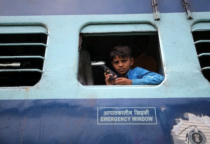 Un niño juega con una pistola de juguete en un tren de Aurangabad, India.