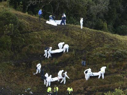 Un grupo de rescatistas traslada los cuerpos de los fallecidos en el accidente a&eacute;reo del Chapecoense.