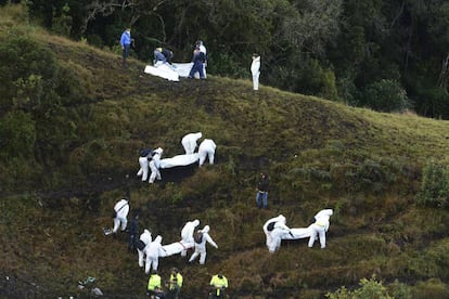 Un grupo de rescatistas traslada los cuerpos de los fallecidos en el accidente a&eacute;reo del Chapecoense.