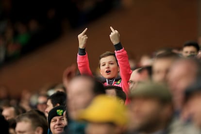 Menos mal que los niños veían el fútbol con una mirada diferente... Aquí uno de ellos con doble dedo corazón en la grada del estadio del Norwich. 