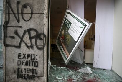 Una oficina del banco Cariparma muy afectada por las protestas contra la inauguración de la Expo de Milán 2015. Las pintadas muestran claramente el mensaje de los manifestantes: "No expo".