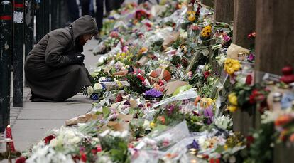 Una mujer deposita un ramo de flores en memoria por las vctimas del ataque terrorista en una sinagoga en Krystalgade en Copenhague. Dos hombres han sido detenidos por colaborar presuntamente con el sospechoso de los atentados de este fin de semana, en los que murieron dos personas y cinco agentes resultaron heridos.