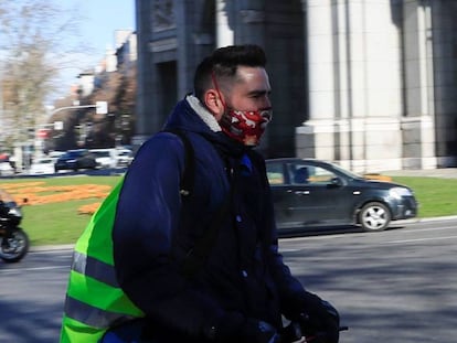 Un hombre circula en un patinete eléctrico por la calzada en la rotonda de la Puerta de Alcalá en Madrid. 