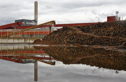 Pilas de troncos situados fuera de una fábrica de papel en Kajaani (Finlandia)