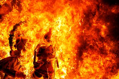 Unos 'ninots' son consumidos por el fuego durante la Cremà infantil de la falla del Ayuntamiento de Valencia.