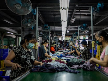 Varios trabajadores clasifican la ropa de segunda mano en una fábrica de reciclaje textil el 15 de julio de 2022 en la ciudad de New Taipei, Taiwán.