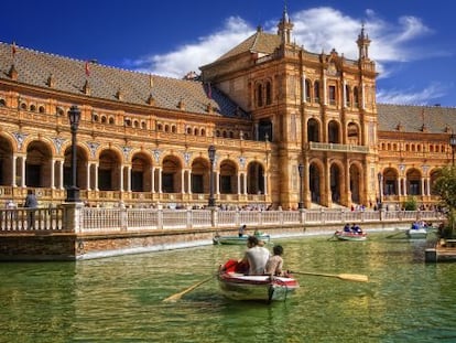 Turistas paseando en barca en la plaza de Espa&ntilde;a, en el parque Mar&iacute;a Luisa de Sevilla. 
