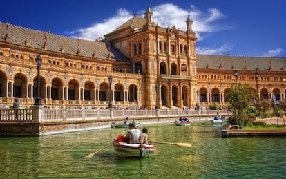 Turistas paseando en barca en la plaza de Espa&ntilde;a, en el parque Mar&iacute;a Luisa de Sevilla. 