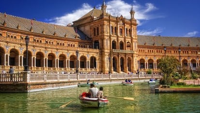 Turistas paseando en barca en la plaza de Espa&ntilde;a, en el parque Mar&iacute;a Luisa de Sevilla. 