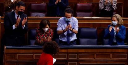 El presidente del Gobierno, Pedro Sánchez (izquierda), la vicepresidenta primera, Carmen Calvo, el vicepresidente Pablo Iglesias y la vicepresidenta y ministra de Economía, Nadia Calviño (derecha) aplauden a la ministra de Hacienda, María Jesús Montero (abajo) tras su intervención durante el Pleno del Congreso.