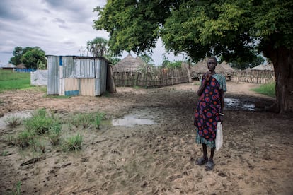 Una mujer posa en la aldea de Panpandiar, frente a un puesto donde solía comprar alimentos. Los dueños del establecimiento se han visto obligados a cerrarlo como consecuencia de las inundaciones.